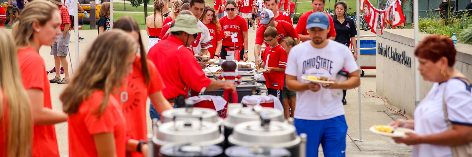 Students lined up to get food at tailgate event.